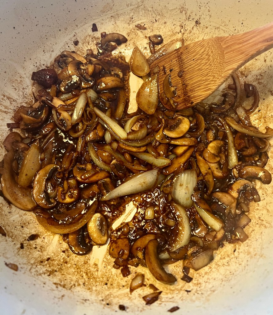 Mushrooms and onions searing in the Dutch oven.